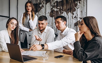Two hands pointing at laptops